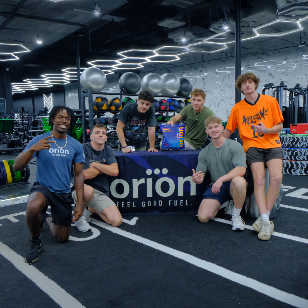 People posing with Orion protein tub in a gym