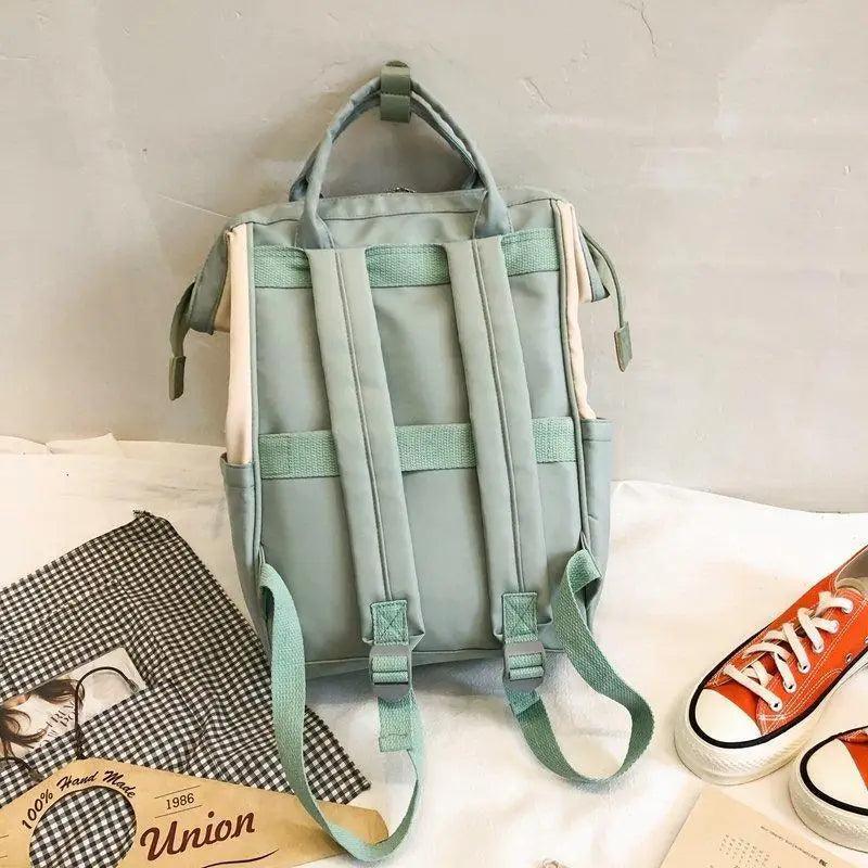 Light green backpack with front compartments and padded back straps