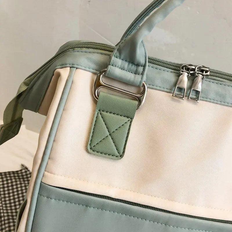 Green and cream patchwork backpack with front pocket, zipper, and adjustable shoulder strap
