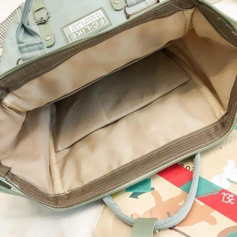 Mint blue backpack interior open with large compartment and zip closure lining.