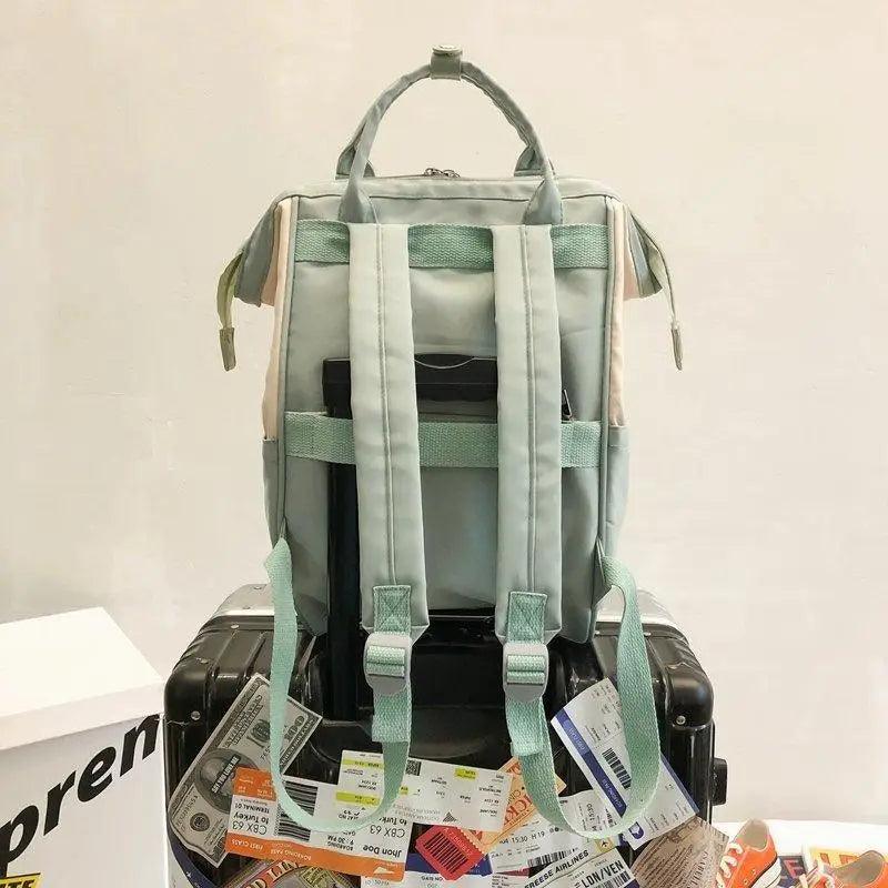 Mint green and cream backpack with padded straps and open top compartments