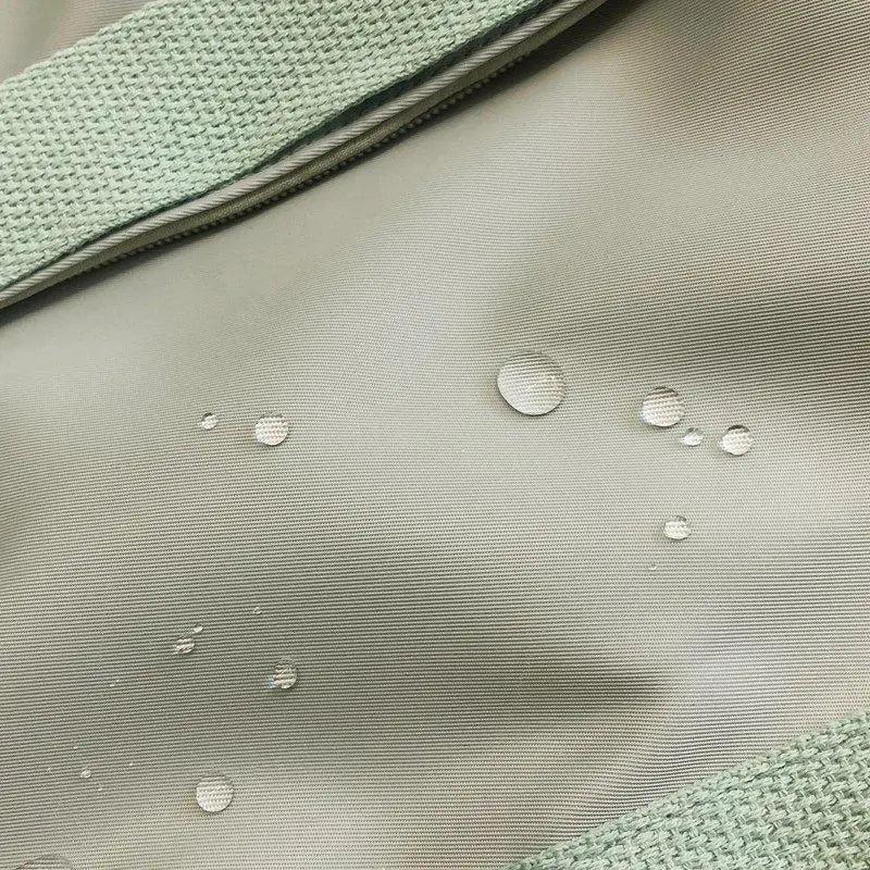 Light gray backpack fabric with small raised dot and water-drop texture pattern.