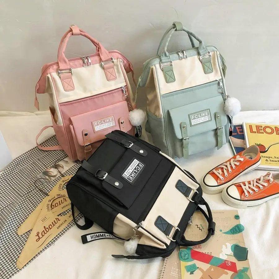 Pink and cream patchwork backpack with front pockets and ring keychain charm.