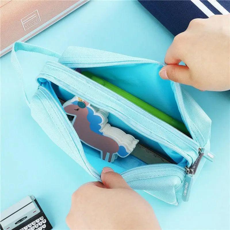 Light blue double-layer pencil case open, showing inner pouch and stationery items