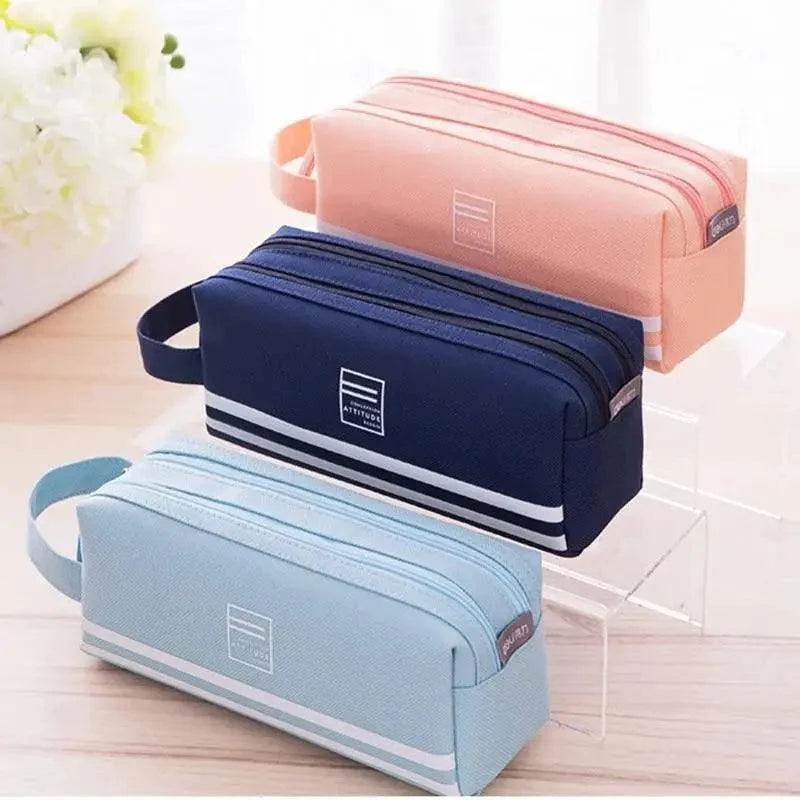 Three zip pencil cases: navy, dusty pink, and light blue with white stripe bands