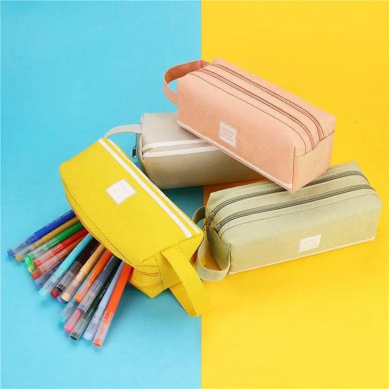 Stacked pencil cases in peach, yellow, and sage green with wrist straps