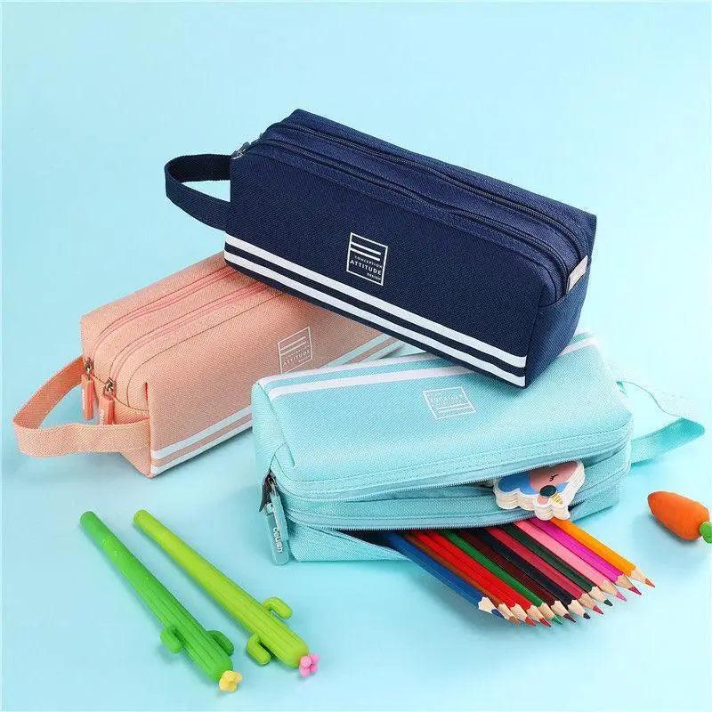 Three double-layer pencil cases in navy, pink, and light blue with straps