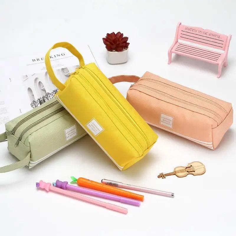 Pink, yellow, orange, and green pencil cases with top zippers and front labels