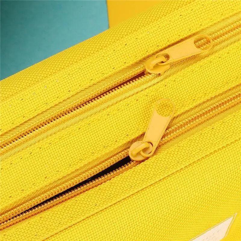 Yellow pencil case with dual zippers and textured fabric surface