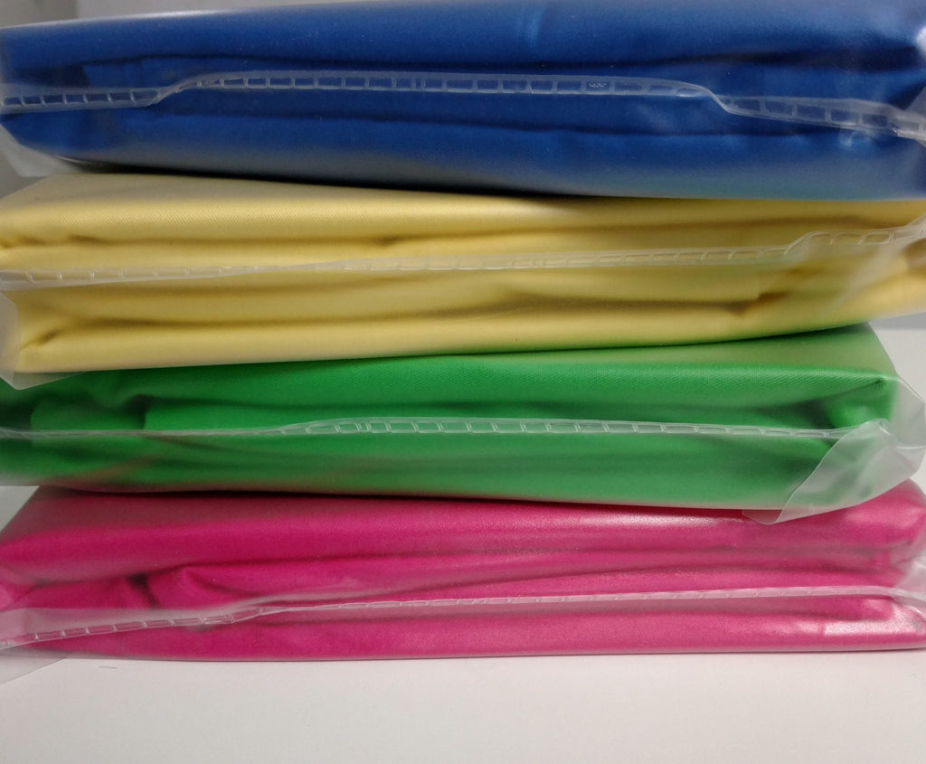 Stack of folded duvet covers in multiple colors, including banana yellow solid cotton