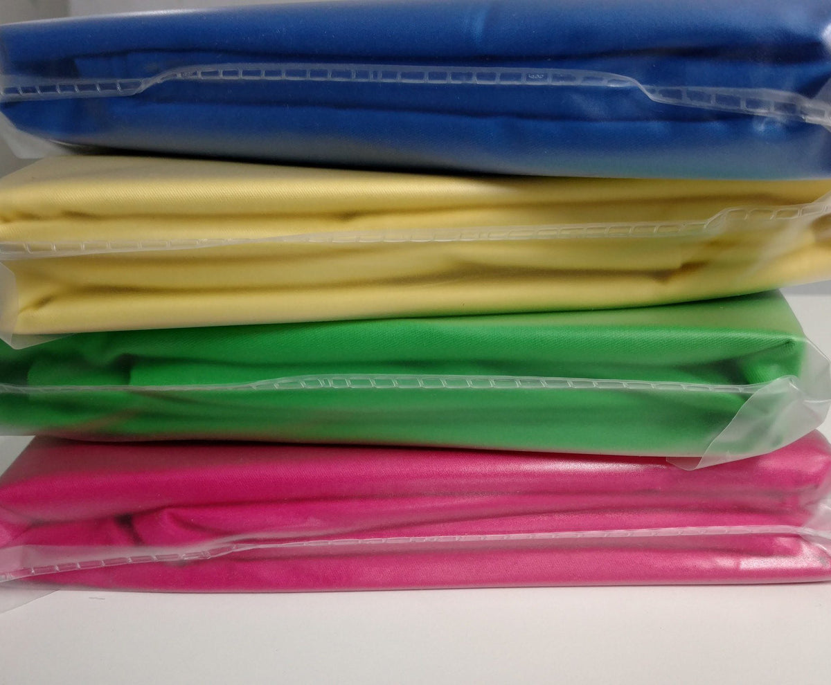 Stack of folded duvet covers in multiple colors, including banana yellow solid cotton
