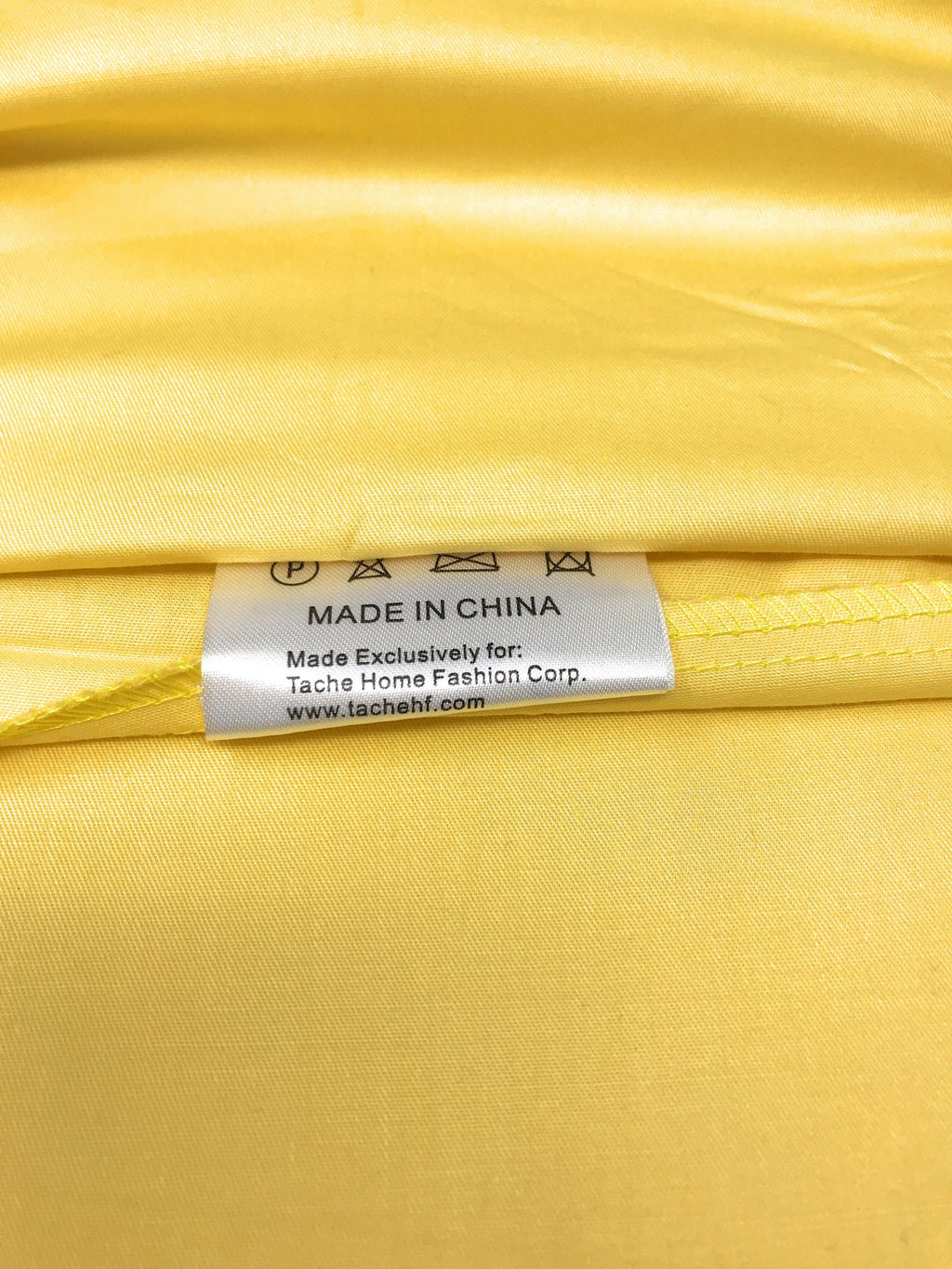 Close-up of banana yellow cotton duvet fabric with label reading made in China