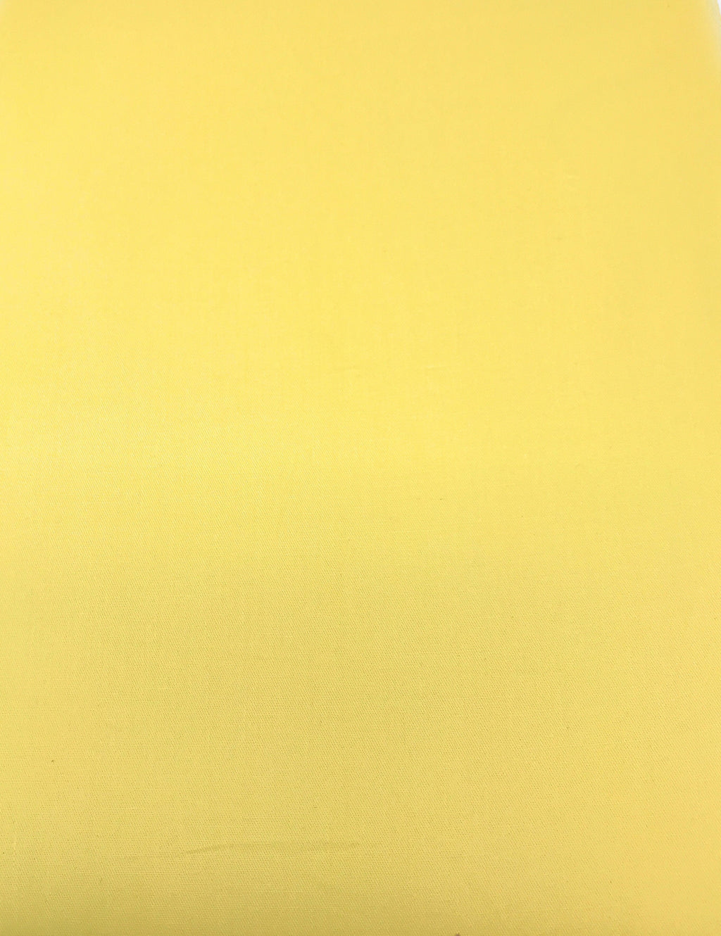 Solid banana yellow cotton duvet fabric surface with subtle woven texture