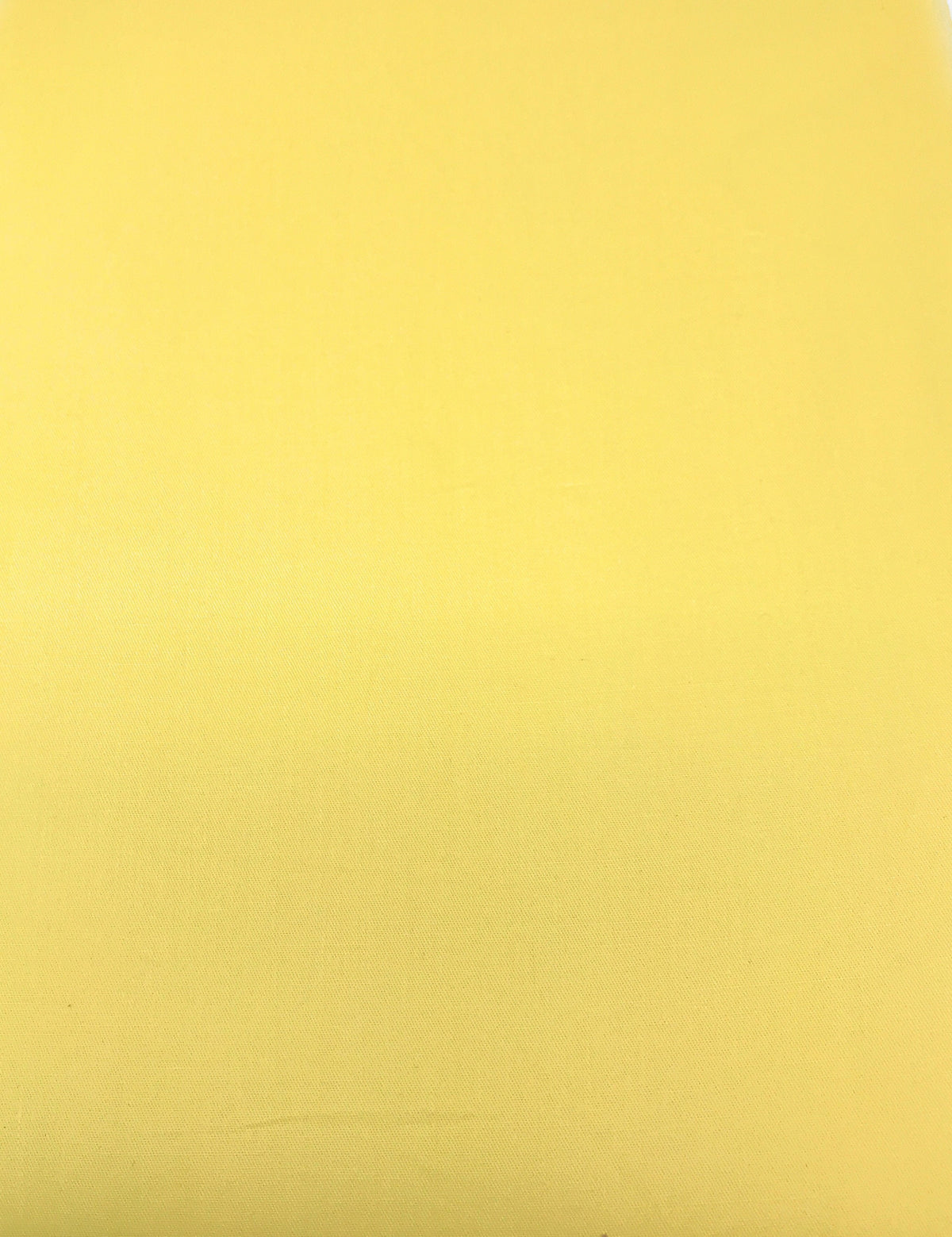 Solid banana yellow cotton duvet fabric surface with subtle woven texture