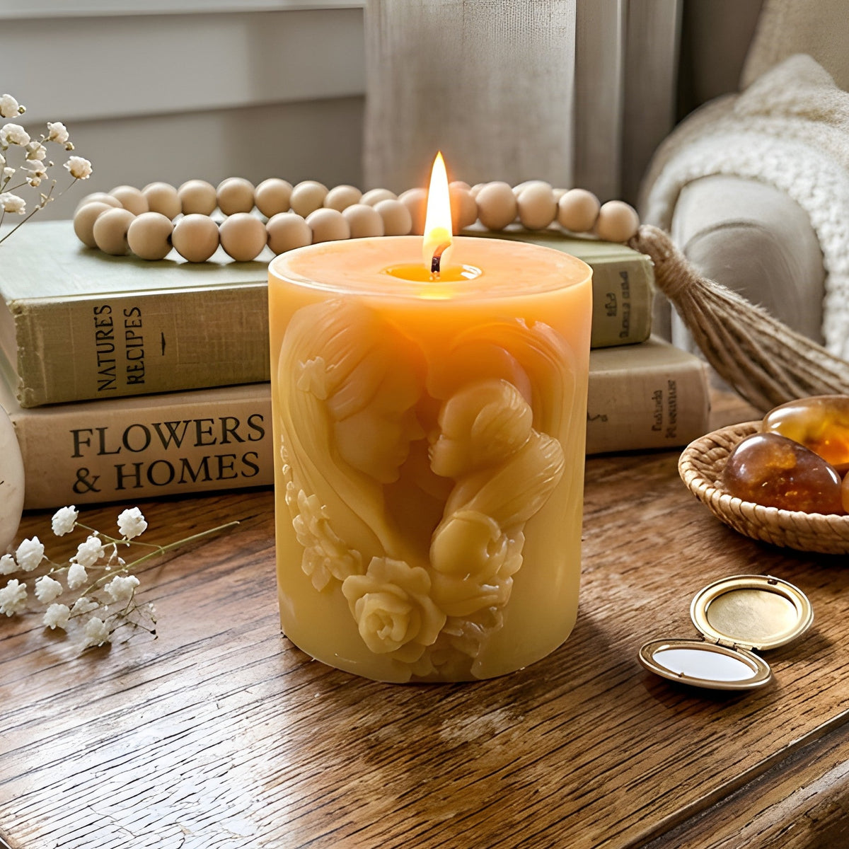Lit beeswax candle with molded mother and floral relief on honey-colored wax