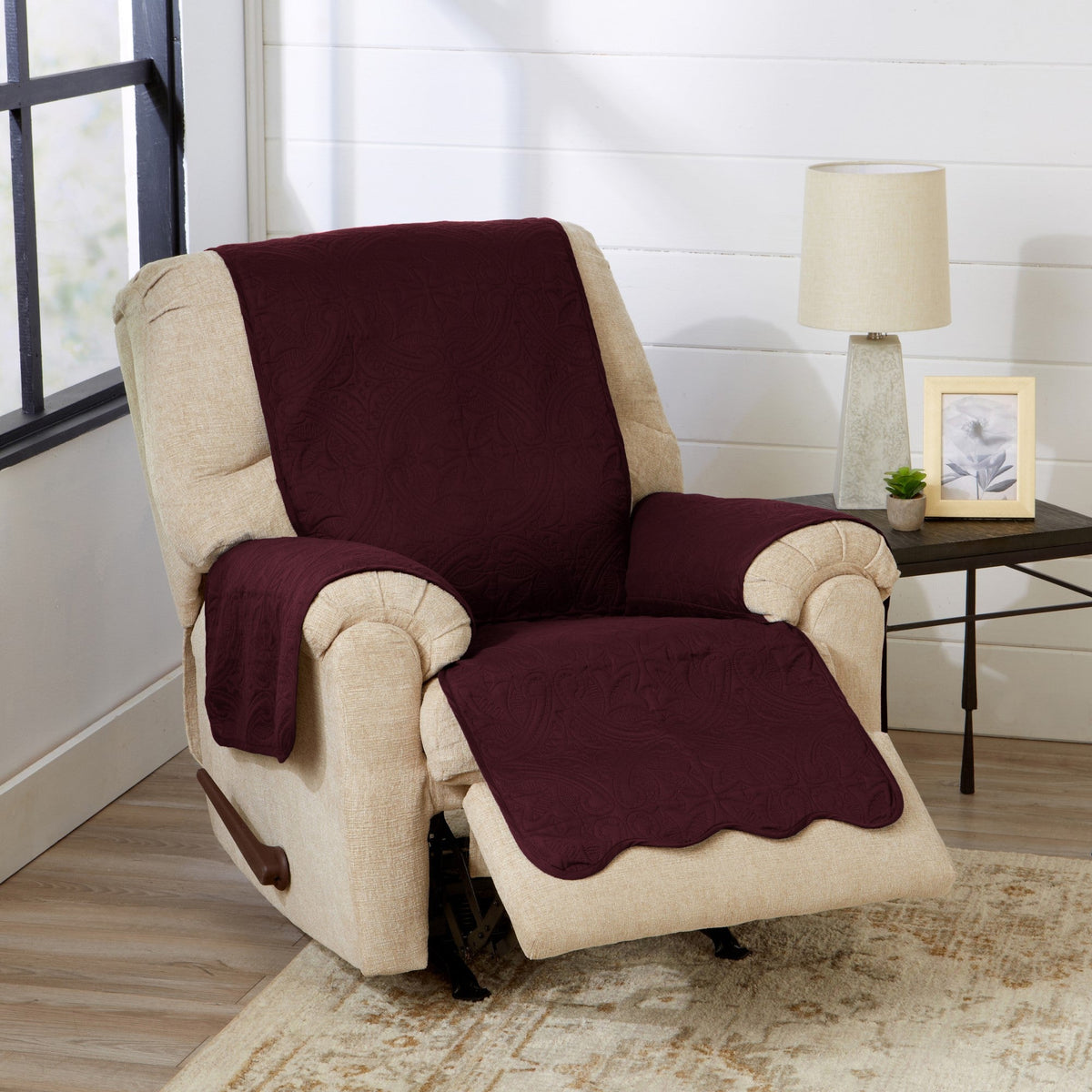 Burgundy recliner protector blanket-style cover on beige recliner chair