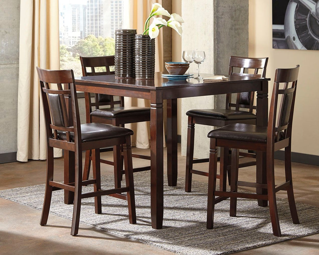 Rectangular brown counter table with four bar chairs and dark seat cushions