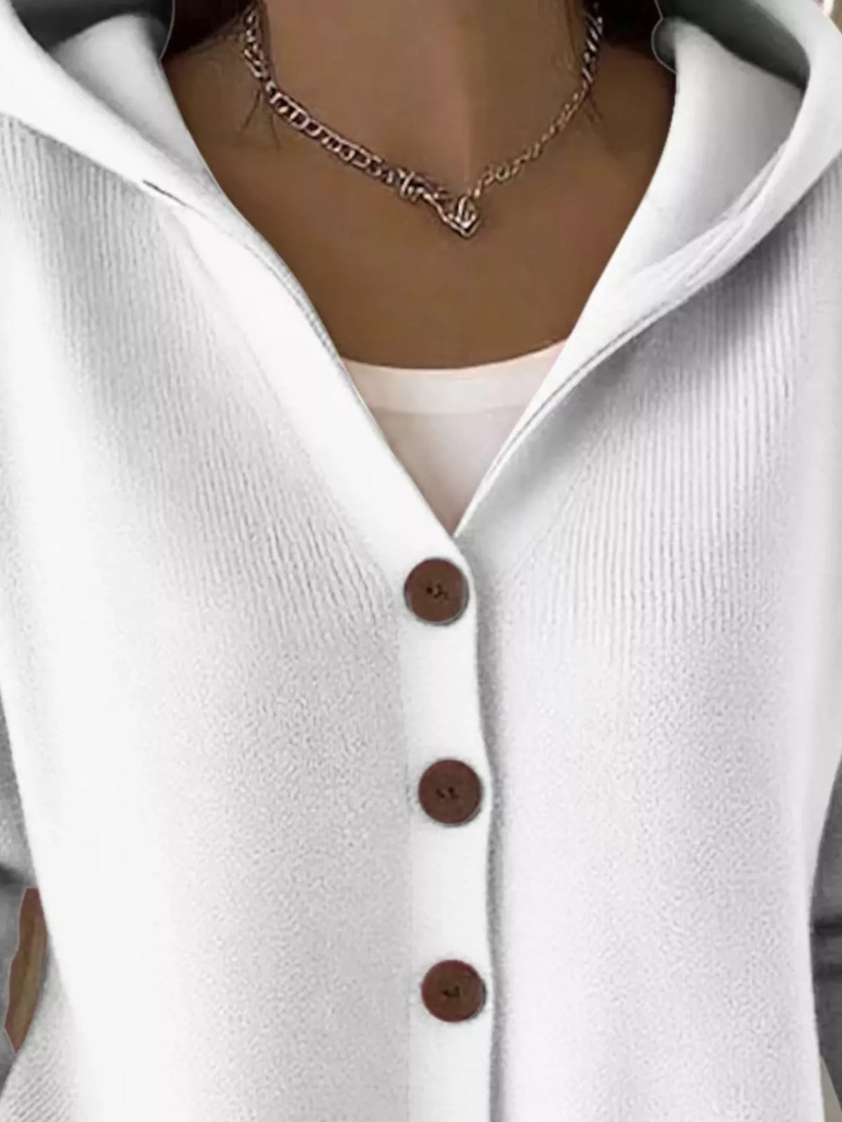 White hooded knit cardigan close-up of hood opening and brown buttons