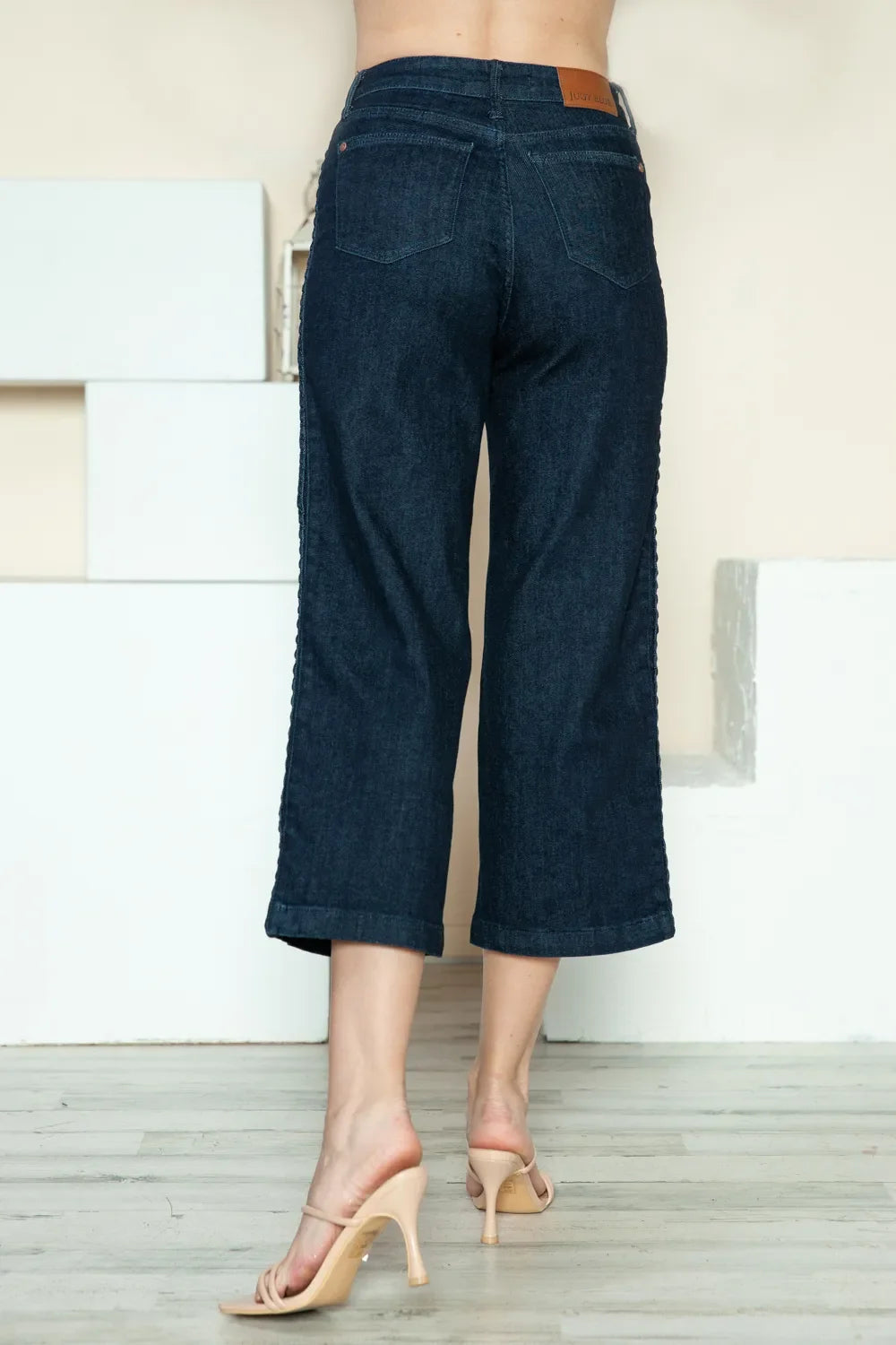 Dark blue denim crop wide-leg jeans with belt loops and back patch pockets.