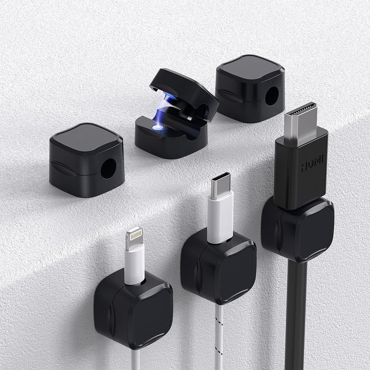 Black magnetic cord holders with adhesive bases for neatly routing cables