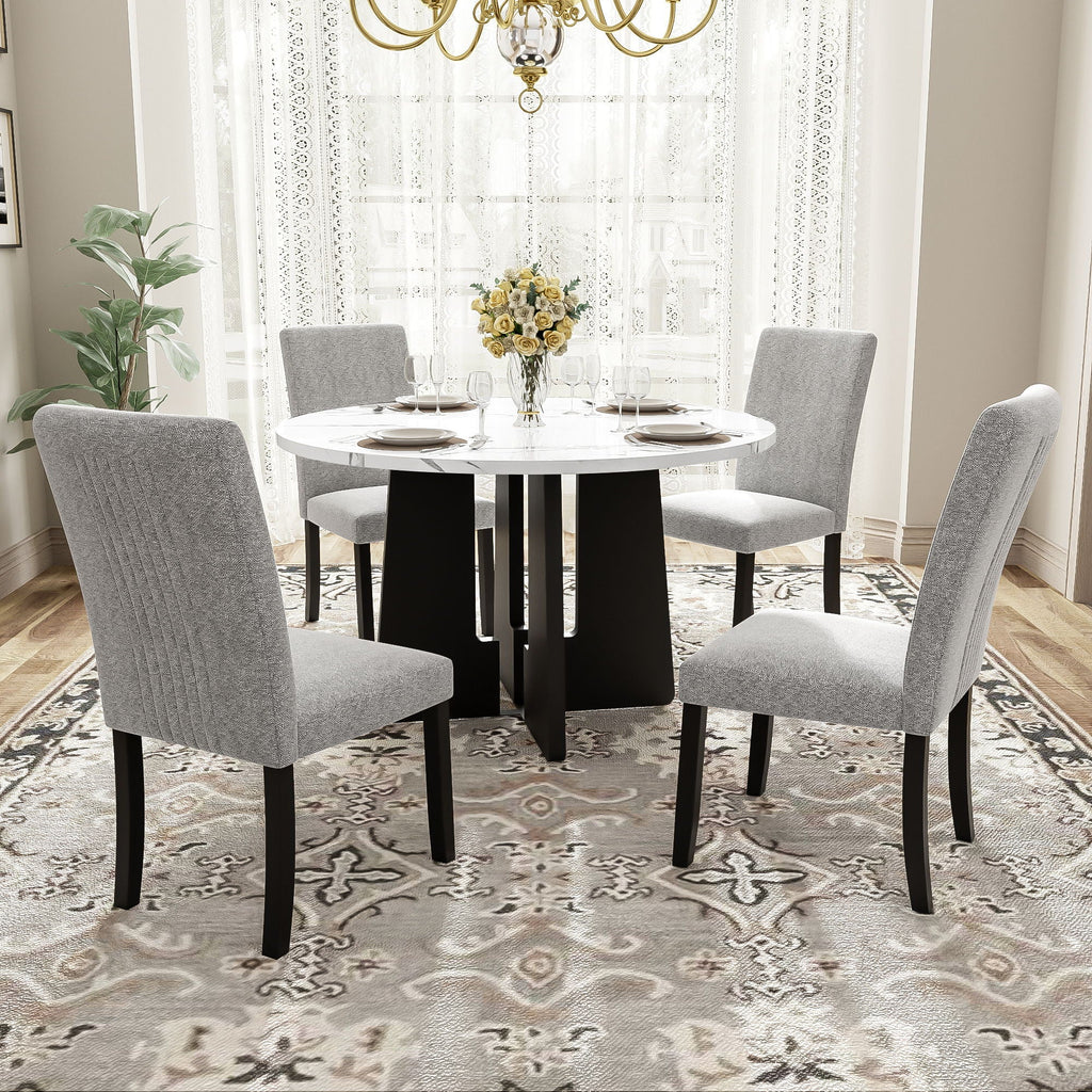 Round white marble-look dining table with four gray upholstered chairs and black legs