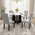 Round white marble-look dining table with four gray upholstered chairs and black legs