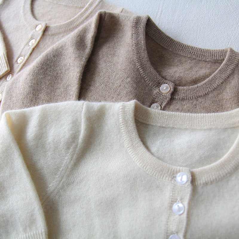 Cashmere pajama onesie close-up, round collar and button front, long sleeves in beige and cream