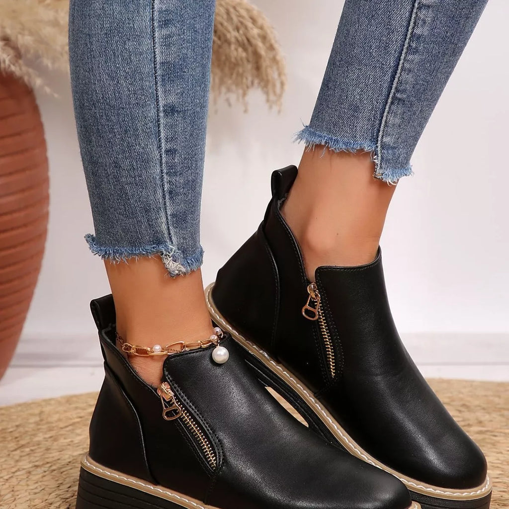 Black ankle boots with side zipper detail and tan-trimmed lug sole