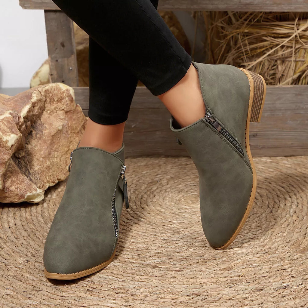 Sage suede block-heel ankle boots with side zipper, stitched seams, and textured sole