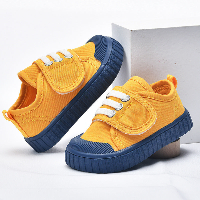 Yellow baby first-walker sneakers with blue sole and white lace-up straps