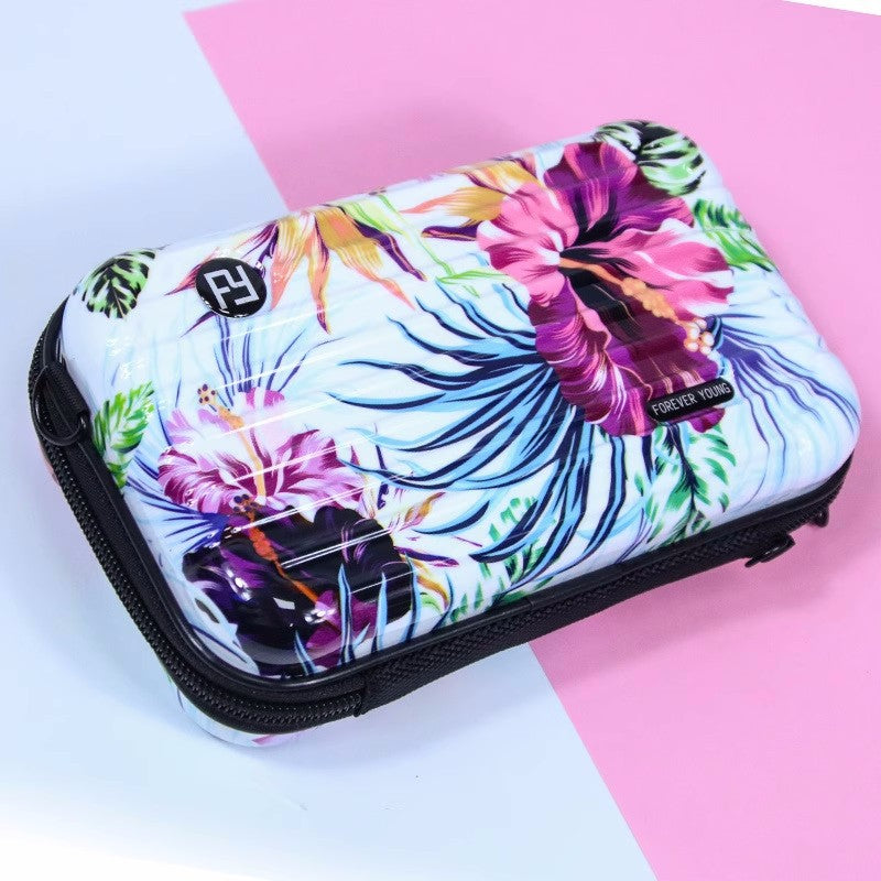 Cosmetic bag with tropical floral print on white, black trim and zip closure