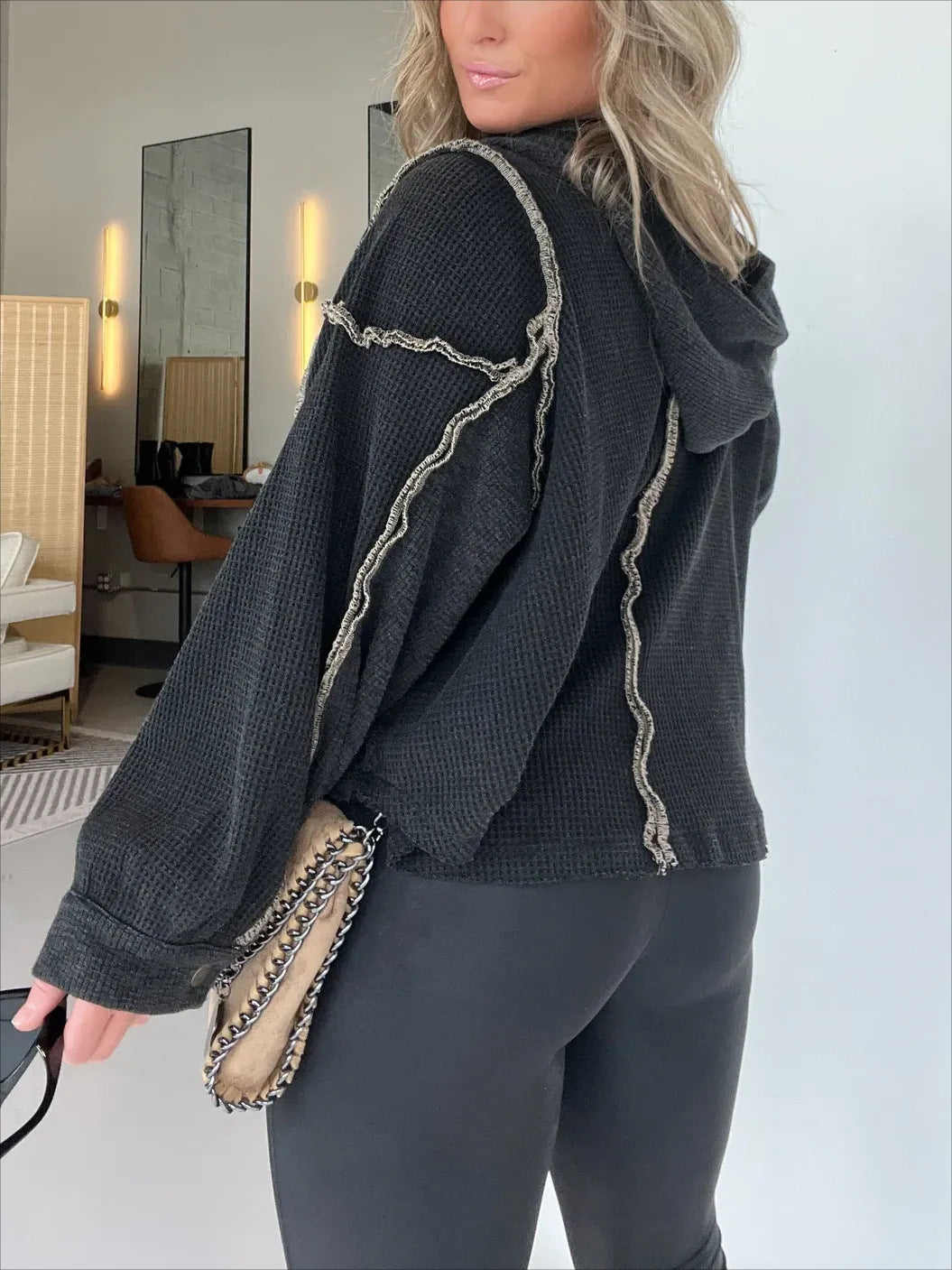 Black textured quarter-zip sweater with contrast rope trim and frayed trim edges