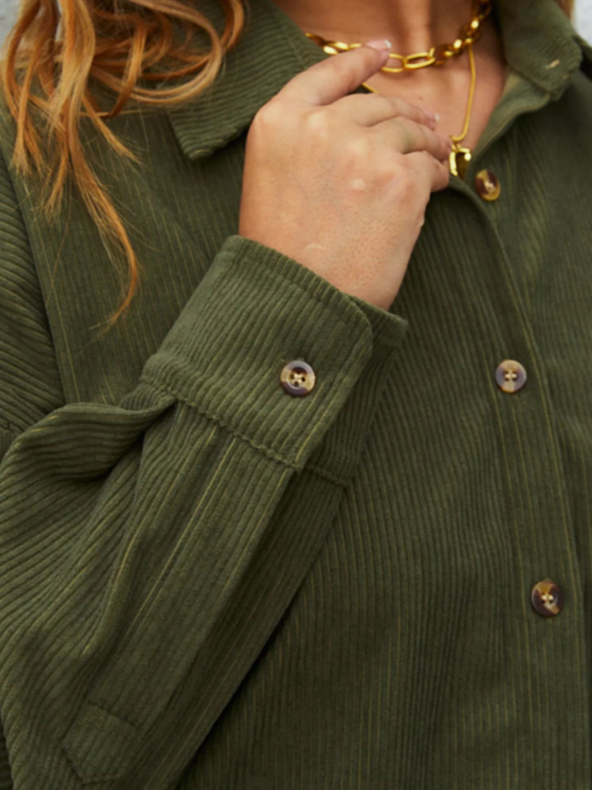 Olive corduroy button-front shirt detail: chest buttons and textured fabric