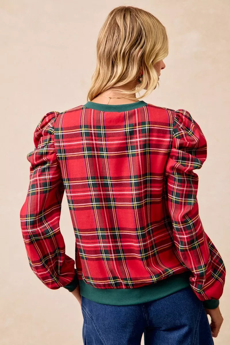 Back view of red plaid top with exaggerated shoulder sleeves and green hem