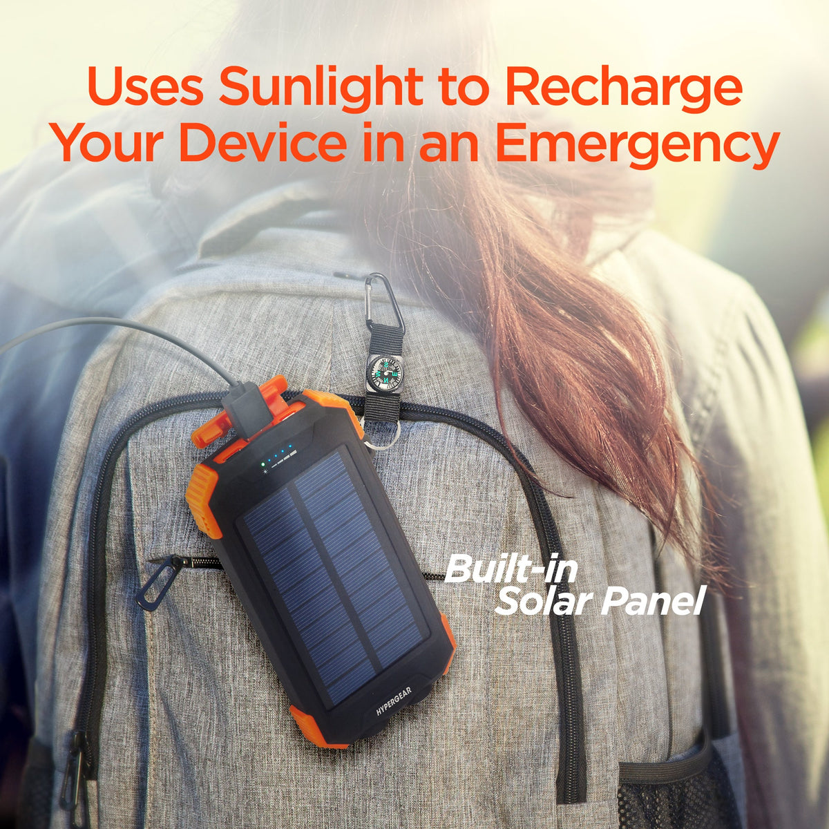 Black and orange solar power bank with built-in panel, clipped to clothing