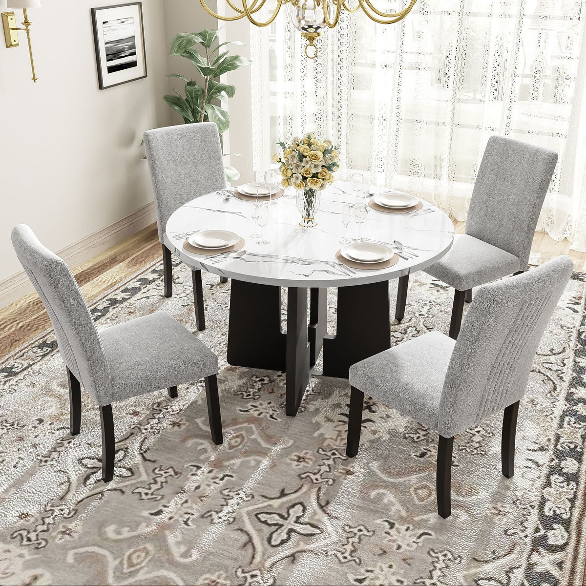 Round white dining table with four gray upholstered chairs around it, black legs