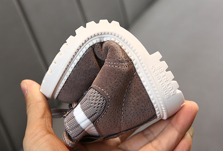 Brown children's ankle boots shown from outsole and toe with tread sole