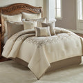 Ivory damask jacquard comforter with embroidered border and decorative pillows, styled