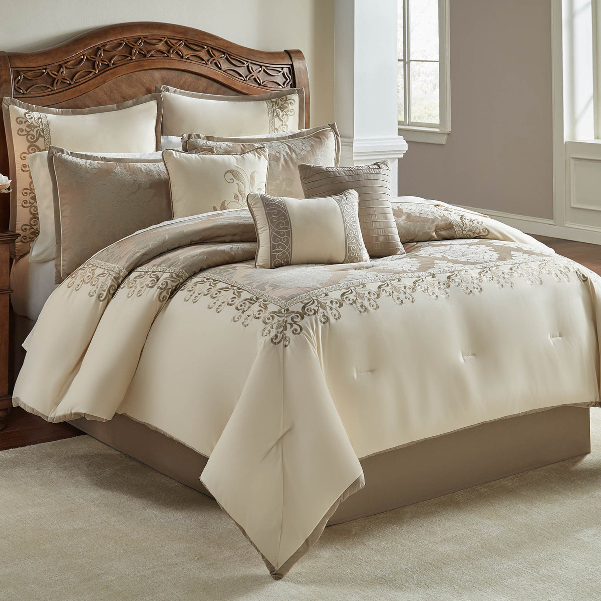 Ivory damask jacquard comforter with embroidered border and decorative pillows, styled