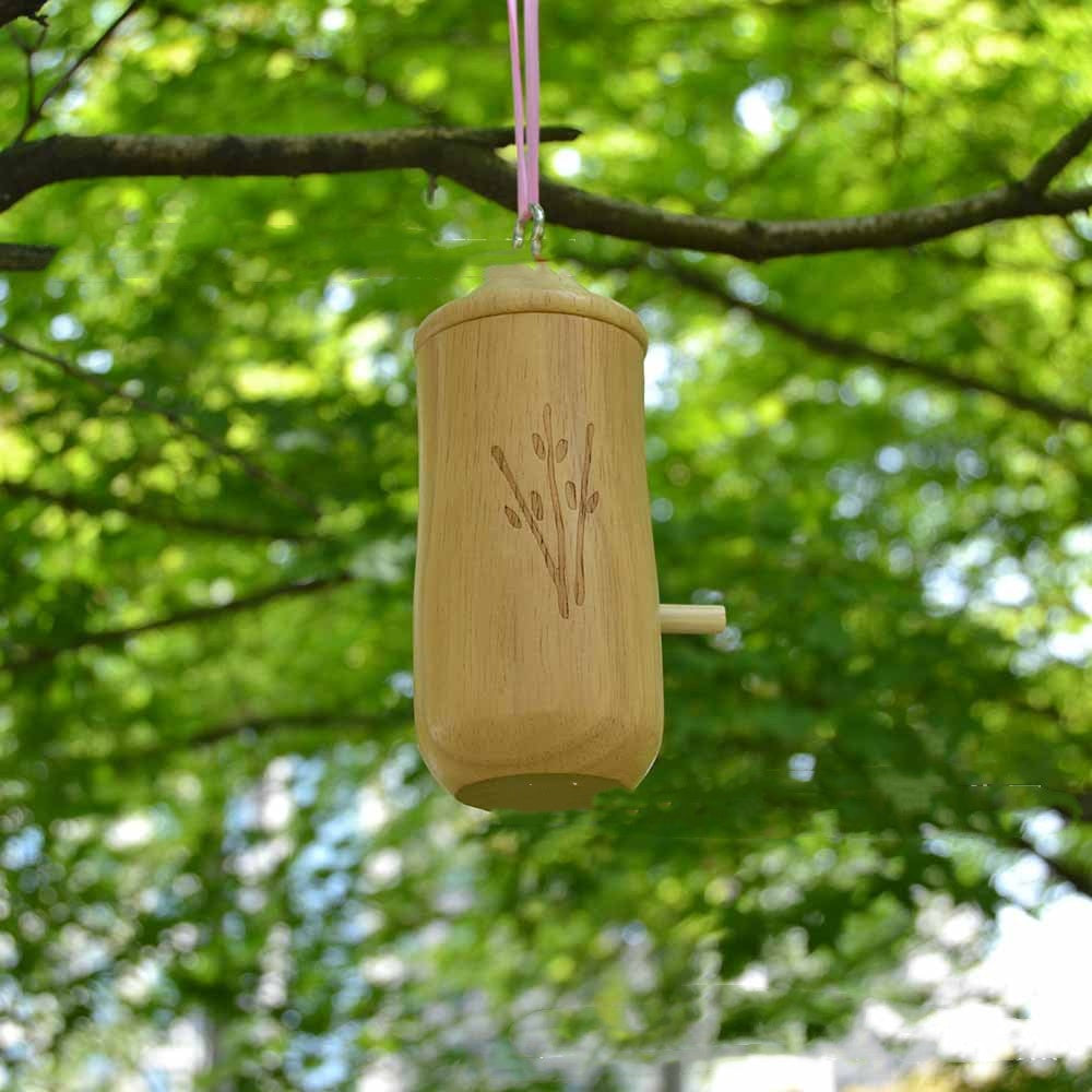 Hanging wooden birdhouse on a branch, with round entry hole and leaf-shaped carving.