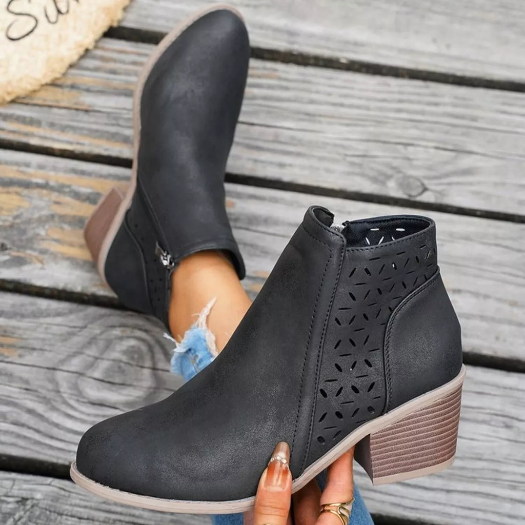 Black ankle boots with block heel and cutout perforations on the side panel