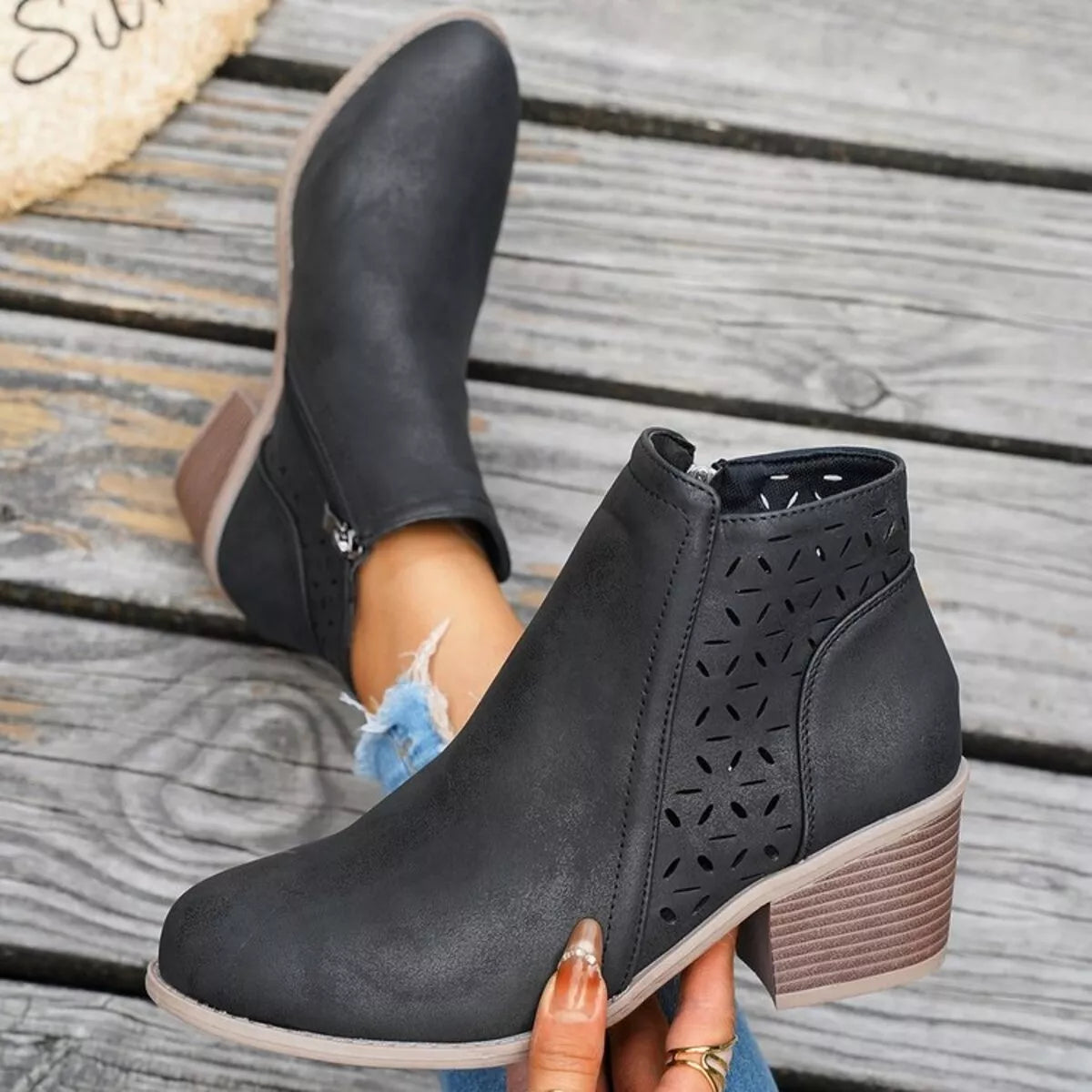 Black ankle boots with block heel and cutout perforations on the side panel
