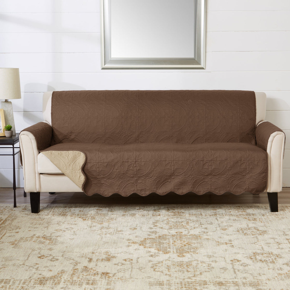 Brown sofa protector with cream arm panels and scalloped-style edge, medallion quilt pattern