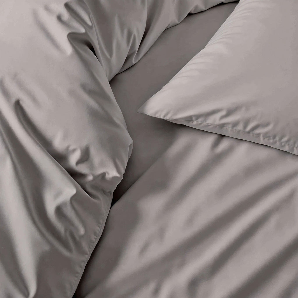 Gray sateen bedding fabric close-up with smooth wrinkle texture