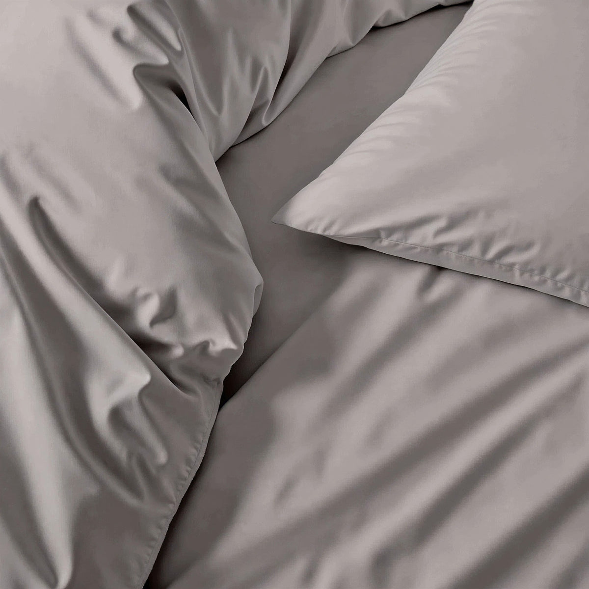 Gray sateen bedding fabric close-up with smooth wrinkle texture