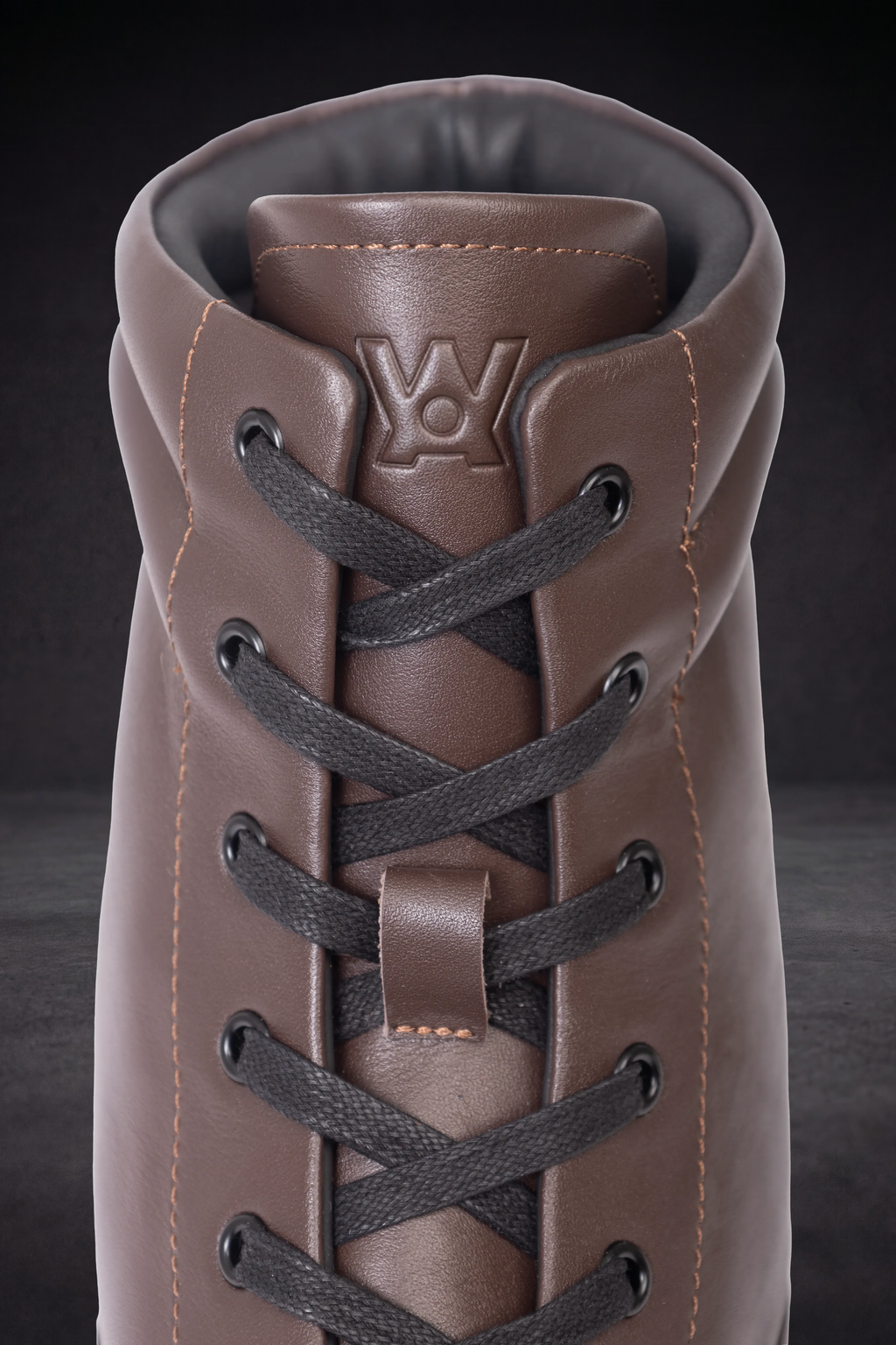 Brown and black lace-up WOA boot with padded collar and visible WOA logo patch