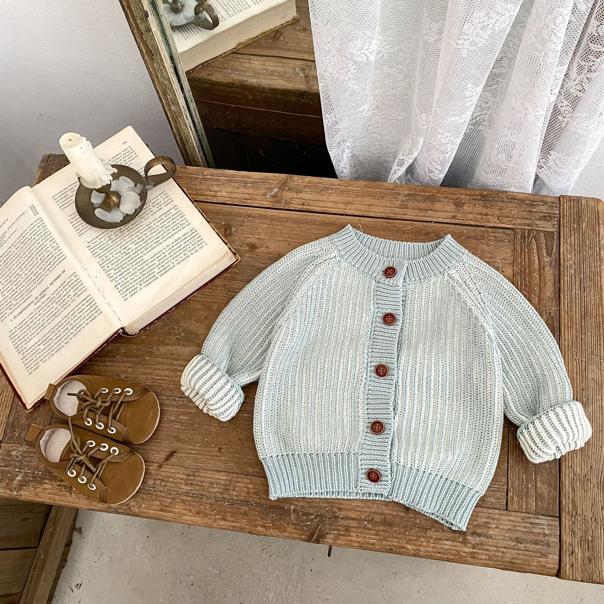 Infant light blue knit round-neck coat with ribbed hem, long sleeves, red button front