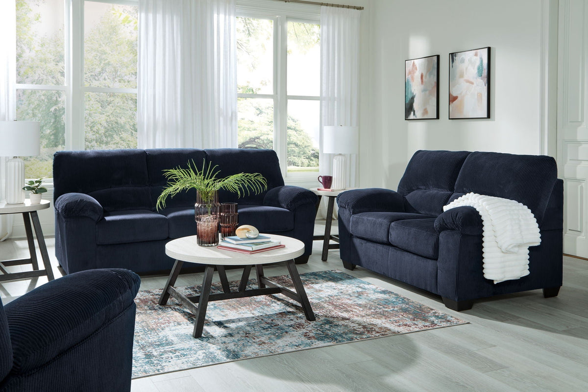 Navy sofa and loveseat set with tufted cushions and accent chair