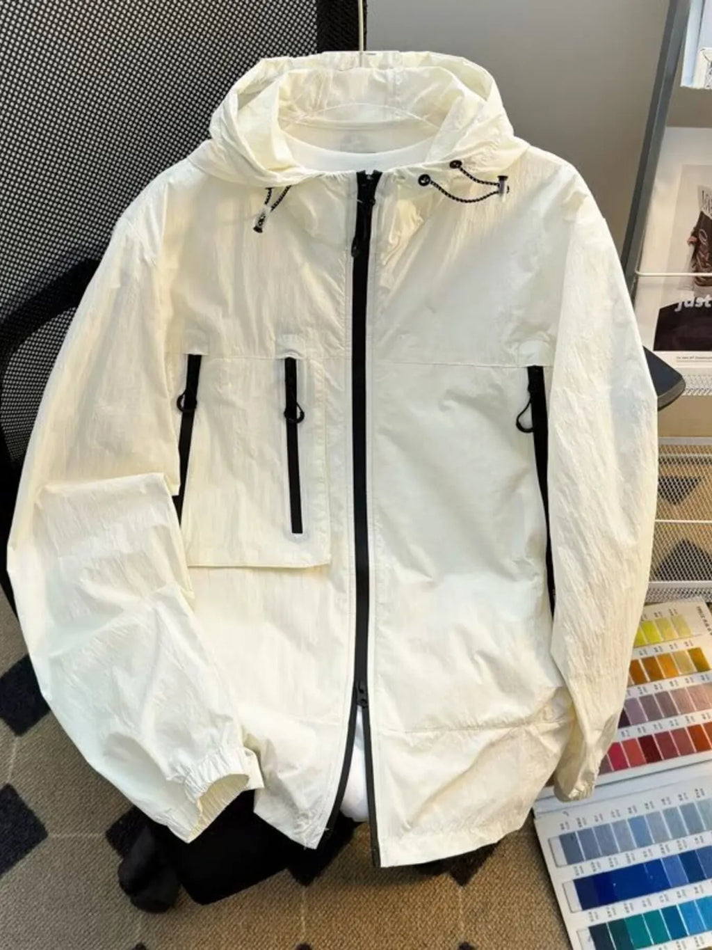 Lightweight hooded windbreaker jacket in off-white with full zip and drawstring hem