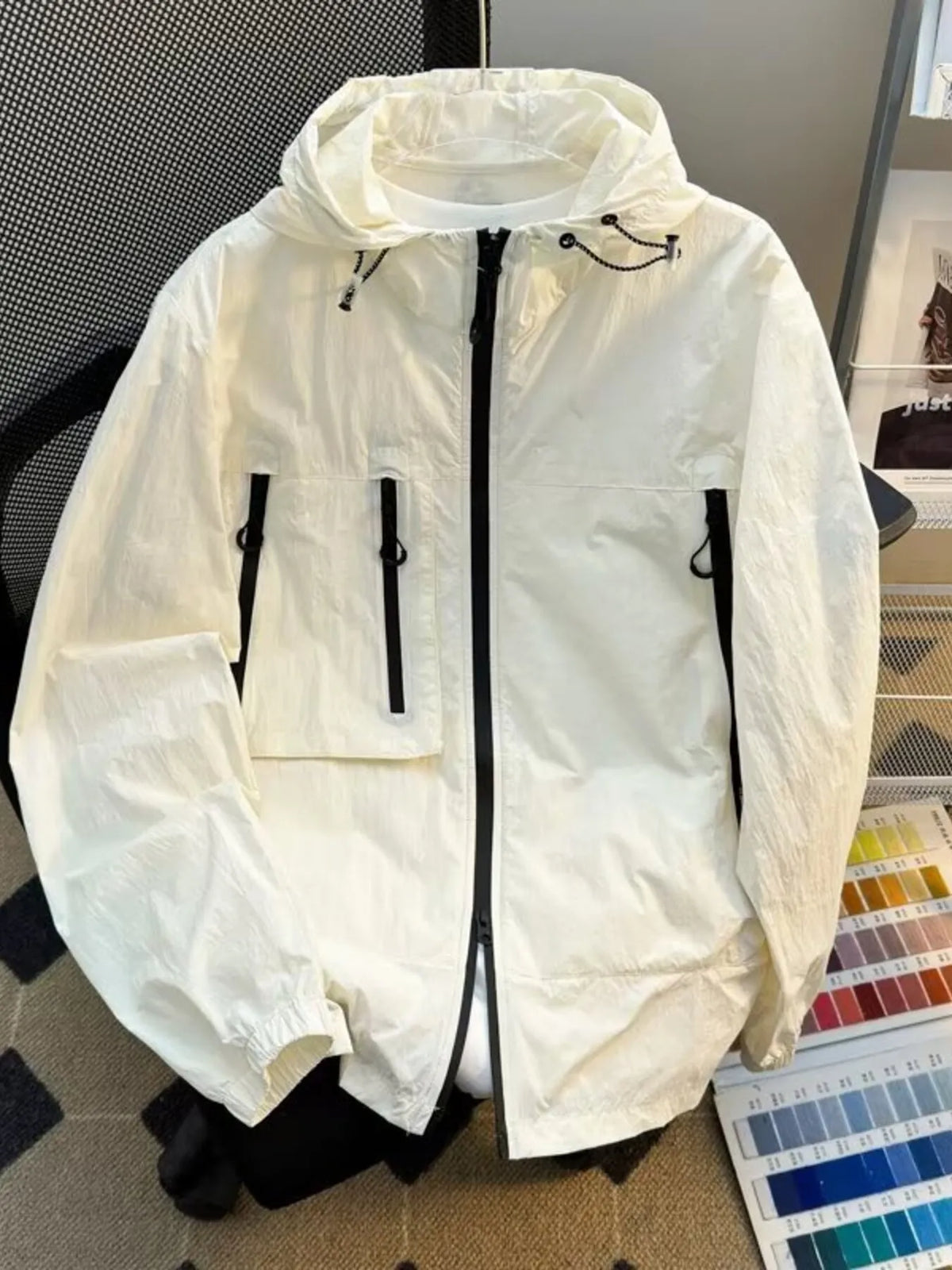 Lightweight hooded windbreaker jacket in off-white with full zip and drawstring hem